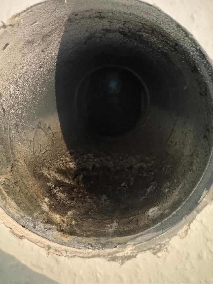 Conduit de ventilation encrassé à l’intérieur du mur, avant nettoyage